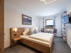 um quarto com uma cama grande e uma estrutura em madeira em Landhaus Barbara em Ramsau im Zillertal