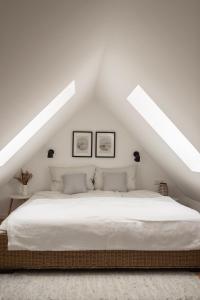 アシャッフェンブルクにあるAltbau Appartement - klein aber ohoの白いベッドルーム(屋根裏に大型ベッド1台付)
