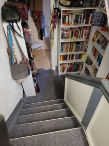 una escalera en una librería con libros en Ferienwohnung Urlaub über den Second Hand Lädchen en Großbreitenbach