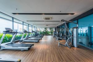 einen Fitnessraum mit einer Reihe von Laufbändern und Maschinen in der Unterkunft The Colony and The Luxe Premier Suites Kuala Lumpur in Kuala Lumpur
