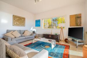 a living room with a couch and a tv at Villa Bendinat 10 - by Priority Villas in Portals Nous