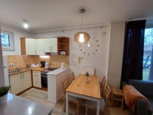 cocina y comedor con mesa y comedor en Semiramis Apartman, en Cserkeszőlő