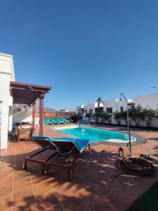 una piscina con un sillón en un patio en Villa Marina1, en Playa Blanca