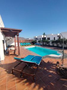 una piscina con un chaise longue en un patio en Villa Marina1, en Playa Blanca