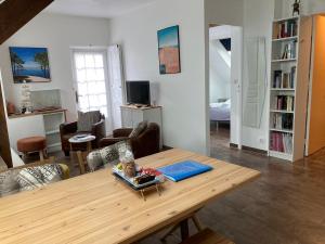 a living room with a wooden table and a living room at 2 pièces, idéalement situé plage et centre ville in Arcachon