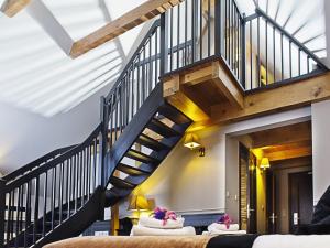 a spiral staircase in a living room with couches at Hotel Holland House Old Town in Gdańsk