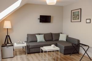 Sala de estar con sofá gris y mesa en Le Relais De La Motte, en Soignies