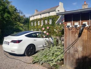 a white car parked next to a wooden fence at La Haute Flourie - bed and breakfast -chambres d'hôtes in Saint Malo