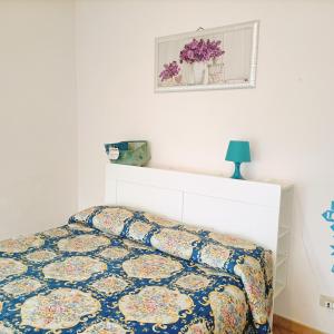a bedroom with a bed with a floral bedspread at La Perla B & B in Ciampino