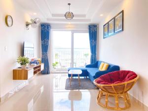 sala de estar con sofá azul y silla en Căn hộ MELODY Vũng Tàu - Mai Oanh Homestay en Vung Tau