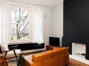 a living room with a couch and a window at Pass the Keys Modern Condo in Brixton in London