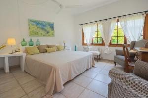 a bedroom with a large bed in a room with windows at Ca na Tinta in Algaida