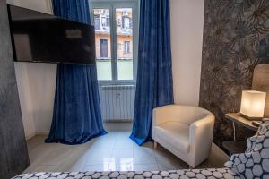 een woonkamer met een tv en een stoel en een raam bij Refuge on Piazza re di Roma in Rome