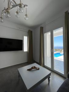 a living room with a table and a large window at White Villas Paros in Kampos Paros