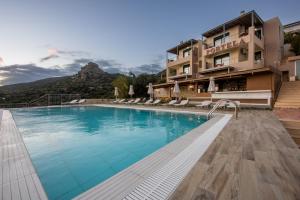 a hotel swimming pool with a mountain in the background at Portela Apartments Kastri in Keratokampos