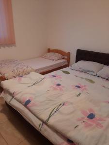 1 dormitorio con 2 camas con flores en las sábanas en Villa Goleš Travnik, en Travnik