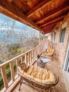 a porch with a couch and chairs on a balcony at THEA STUDIOS Eurostina in Pírgos