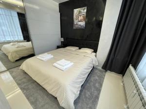 a bedroom with a bed with two towels on it at Luxury Central Apartment Verila in Sofia