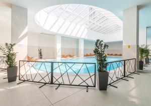 einen Pool mit Glastisch in einem Gebäude in der Unterkunft Oak Sky Apartment Spa & Fitness in Skopje