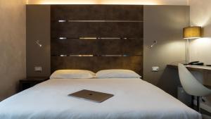 laptopa na górze łóżka w pokoju w obiekcie CAVALLO Hotel Noventa di Piave w mieście Noventa di Piave
