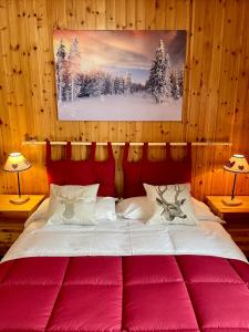 1 dormitorio con 1 cama grande con colchas rojas en Case Vacanza Perron, en Sauze dʼOulx