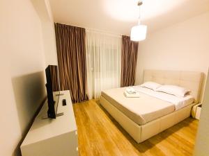 um quarto com uma cama e uma televisão de ecrã plano em Luxurious Retreat 1BR Apartment with Netflix, Private Parking and self check in em Popeşti-Leordeni