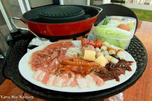 a plate of food with meat and vegetables on a grill at บ้านสวนมะม่วงรีสอร์ท 