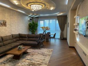 uma sala de estar com um sofá e uma mesa em Meqafun Sea View apartment em Baku