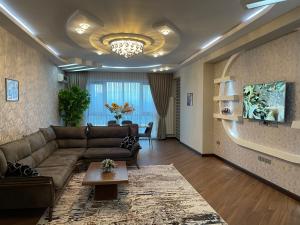 een woonkamer met een bruine bank en een tafel bij Meqafun Sea View apartment in Baku