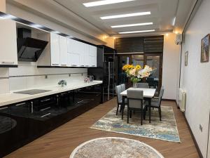 a kitchen with a table with chairs and a vase of flowers at Meqafun Sea View apartment in Baku