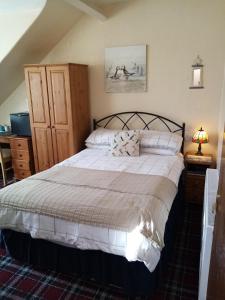 um quarto com uma cama grande e lençóis brancos em Schofield Guest House em Bridlington