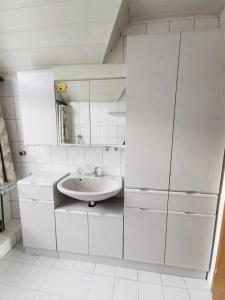 a white bathroom with a sink and a mirror at Elisabeth Stube in Neuss