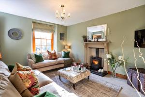 a living room with a couch and a fireplace at Finest Retreats - Ivy Cottage in Casterton