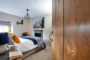 a bedroom with a bed and a fireplace at Finest Retreats - Ivy Cottage in Casterton