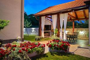 um pavilhão com flores, uma mesa e cadeiras em Villa Sierra em Sinj