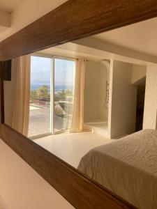 a bedroom with a large window and a bed at LES SUITES LOVE 3 SPA VUE MER PISCINe in Marseille