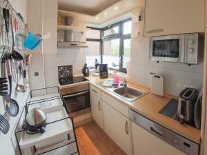 a small kitchen with a stove and a sink at Ferienhaus Marisol, FeWo Vermittlung Nordsee in Dangast