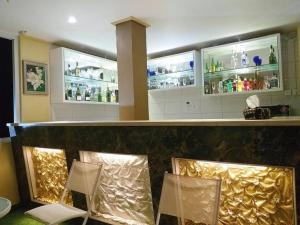 a bar with three chairs and a counter with drinks at MY HOME @BALI HOTEL BY CONARY in Kuta