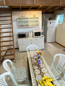 uma pequena cozinha com uma mesa e cadeiras e um frigorífico em Casa na Praia de Palmas em Governador Celso Ramos