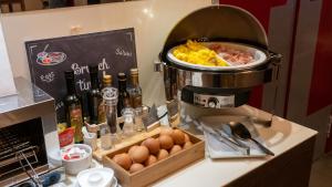 un mostrador con cafetera y huevos en AMEDIA Hotel, en Noventa di Piave