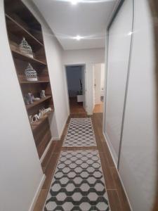 a hallway with a black and white floor and shelves at Nene in Banja Luka