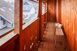 einen leeren Balkon mit einem Tisch und zwei Fenstern in der Unterkunft House Pr'Belej in Zgornje Gorje