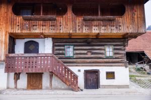 ein Holzgebäude mit einer Treppe davor in der Unterkunft House Pr'Belej in Zgornje Gorje