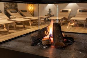 a fire in a room with tables and benches at Guest House Valentincic in Nova Gorica