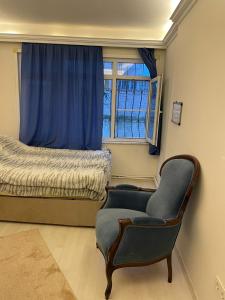 a bedroom with a chair and a bed and a window at kadıköy modada denize yakın oda in Istanbul