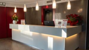 a lobby with a reception desk with a laptop on it at AMEDIA Hotel in Noventa di Piave