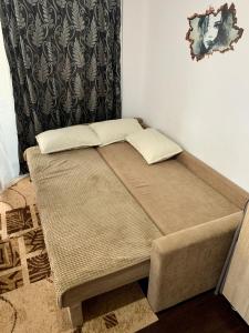 a bed with two pillows on it in a room at At Home in Iaşi