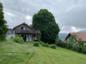 a house on the side of a grass field at Le Chalet de Juliette in Gérardmer