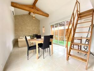uma sala de jantar com uma mesa de madeira e cadeiras em Maison chaleureuse proche de toutes commodité em Biganos