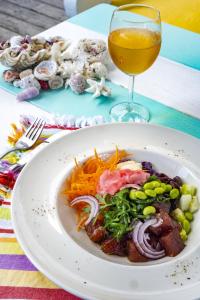une assiette de nourriture sur une table avec un verre de vin dans l'établissement Papaya Villa, à Port Vila